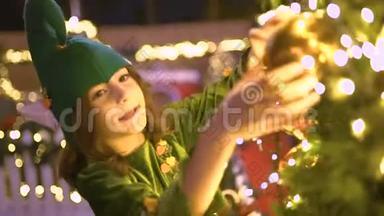 快乐的孩子穿着精灵服装在圣诞节地区玩。 圣诞老人`助手在玩玩具，庆祝圣诞节，装饰